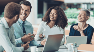 Team aziendale sorridente che pianifica la formazione dopo aver scelto di aderire ai Fondi Interprofessionali.